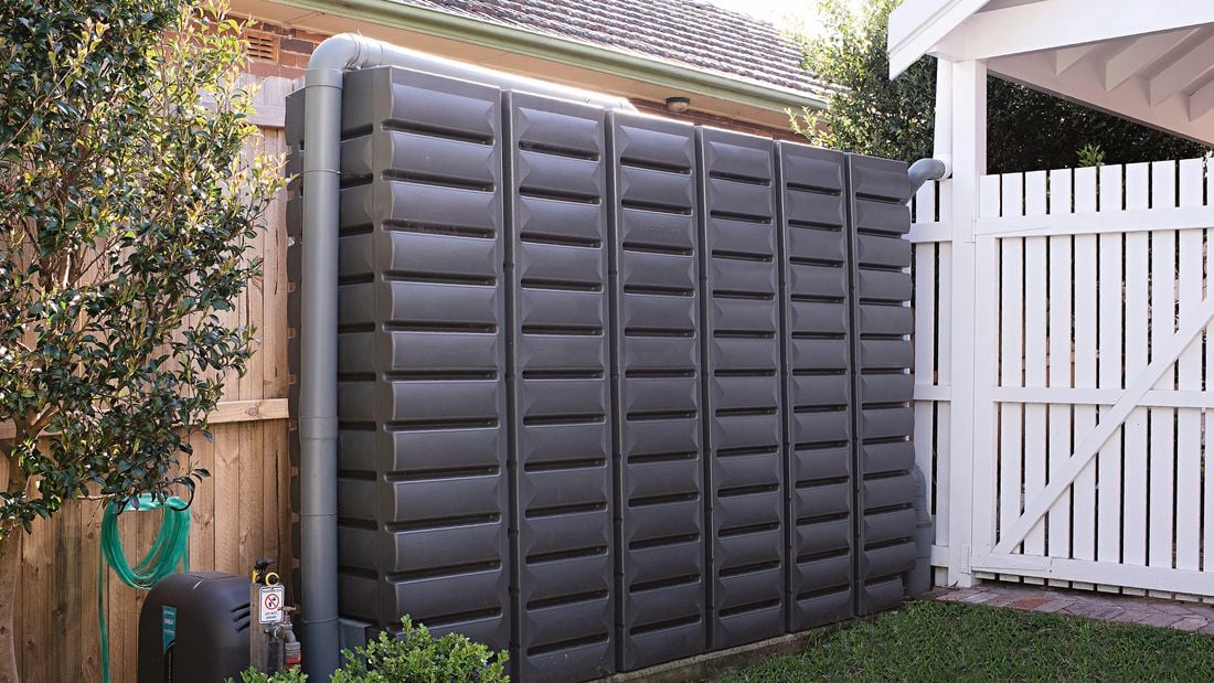 Rectangle water tank in the backyard near wooden fence