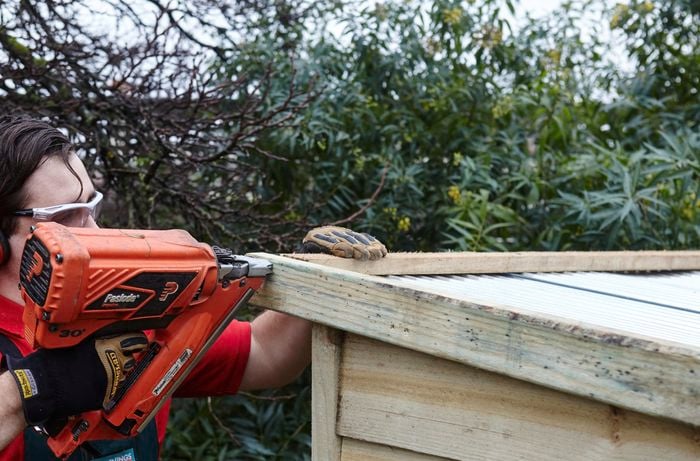 The ends of a roof being nailed into place by a Bunnings team member with a nail gun