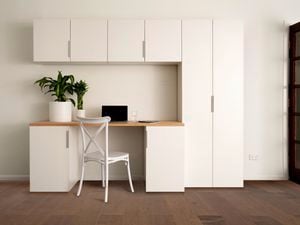 Study space with white cabinets, chair and laptop.