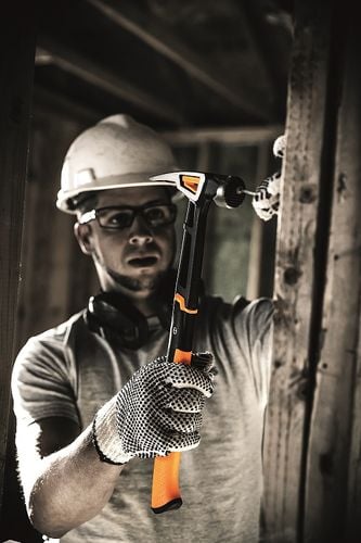 Gritty photo of a man hammering in a nail with a hammer