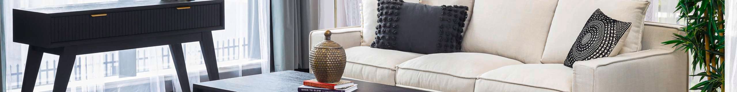 Black hall table with a cream-coloured couch by Divano