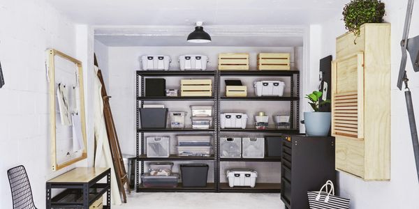 An organized and spacious garage with storage cabinets, wall-mounted racks, and a clean floor finish.