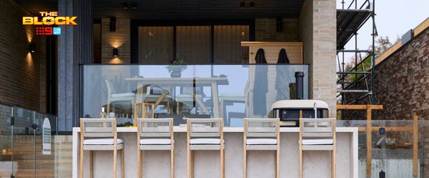 Outdoor entertaining area featuring a poolside bar with timber stools, glass balustrade and covered dining area.