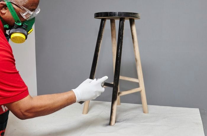 A finished bar stool being spray painted black