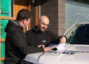 A Bunnings account manager looking at house plans on the hood of this Ute.