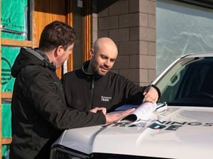 A Bunnings account manager looking at house plans on the hood of this Ute.