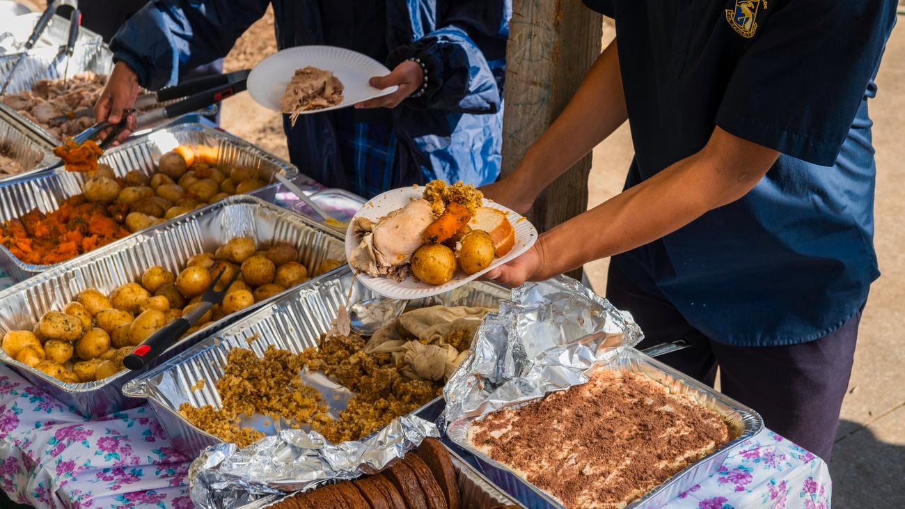 A person serving food onto a plate.