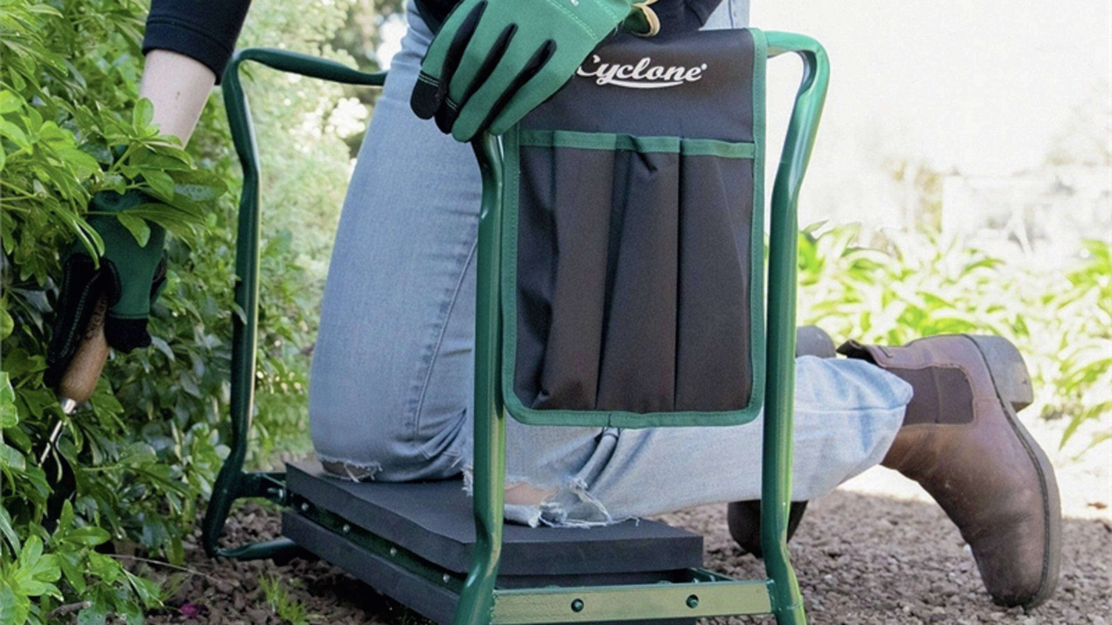 A person using accessible garden tool the Cyclone foldable seat/kneeler in the garden]