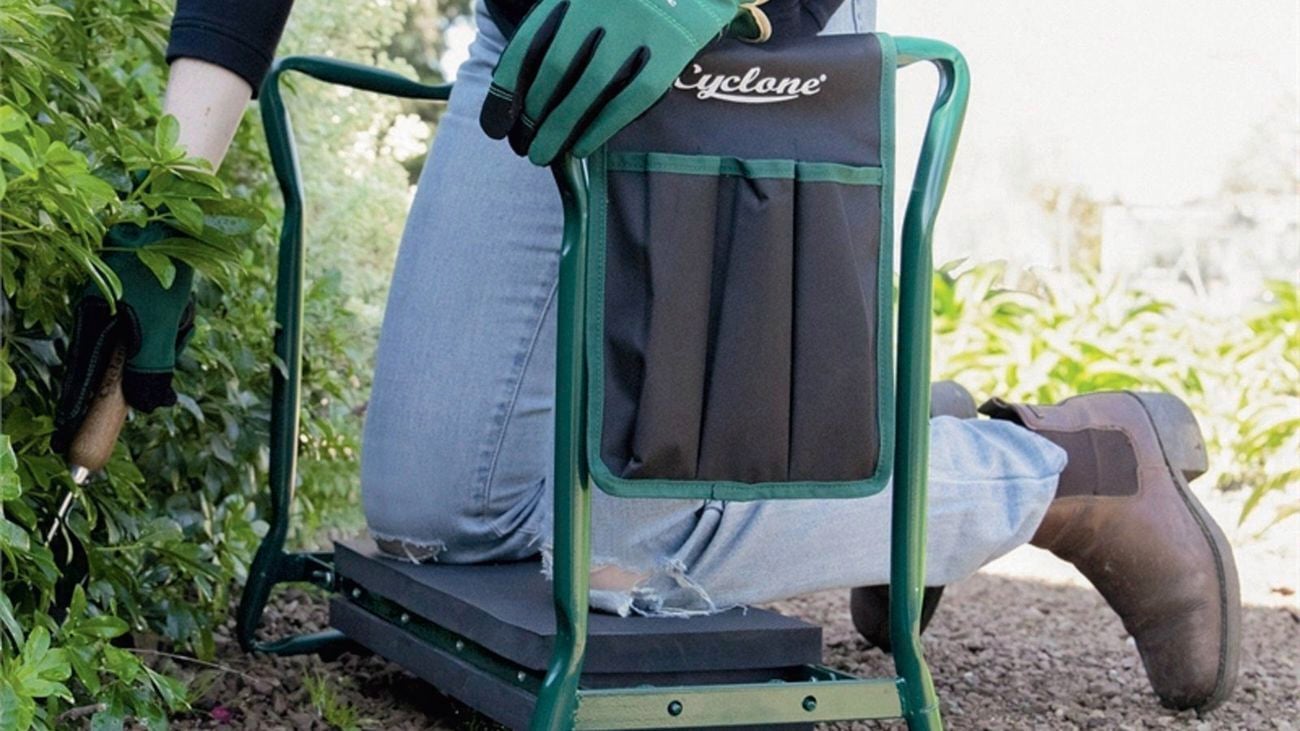 A person using accessible garden tool the Cyclone foldable seat/kneeler in the garden]