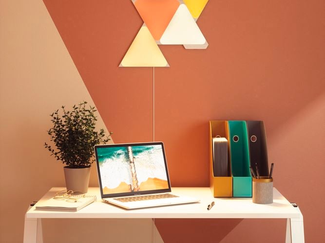 4 smart light panel layout mounted onto a wall behind a desk setup.