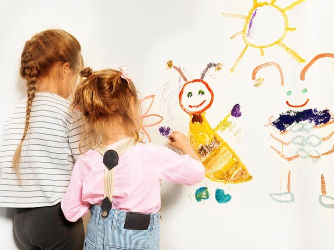 children drawing on a wall