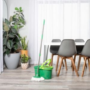 Mop and bucket with table and chairs in a dining area