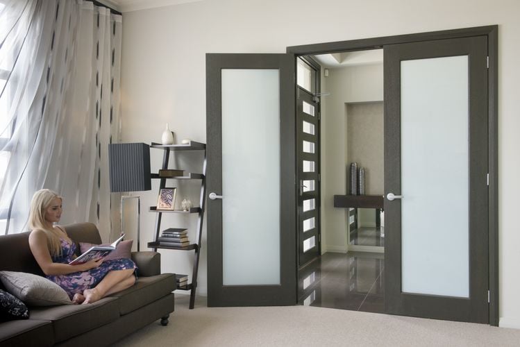Woman reading a magazine in a lounge area with smoked glass doors