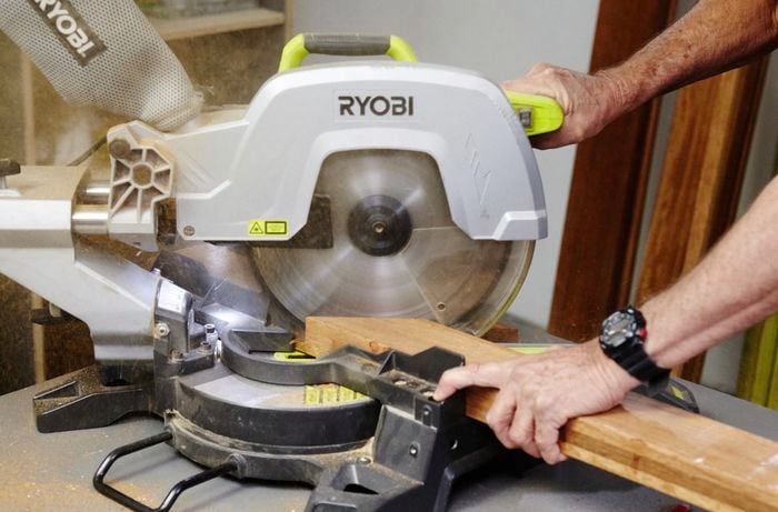 Person cutting timber frames out with circular saw.