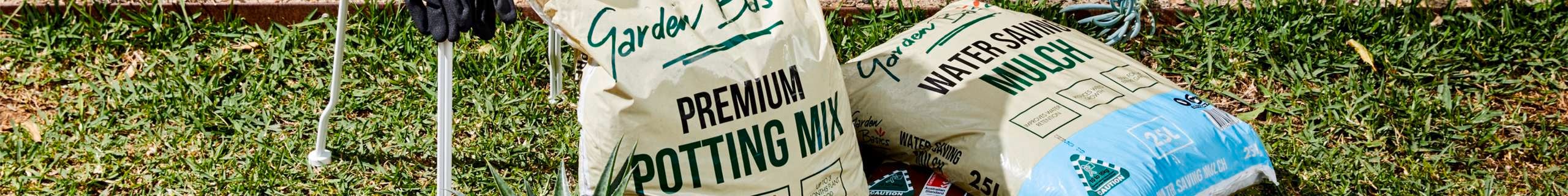 Potting mix bags laid out on a lawn.