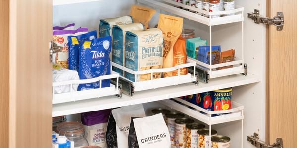 Organised pantry cupboard featuring pull-out storage drawers and shelves