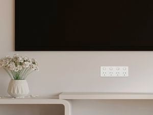 Large flat screen TV mounted on the wall above power sockets