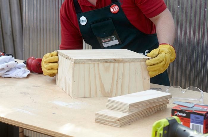 Person lining up pieces of timber to glue and then nail together