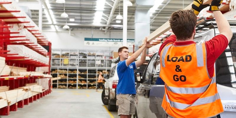 Trade Load & Go -team member helping customer load timber onto a car roof rack in a Bunnings timber yard