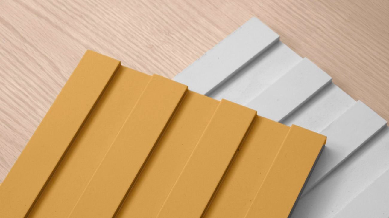 Yellow and white pieces of Laminex wall panel with paint brush.