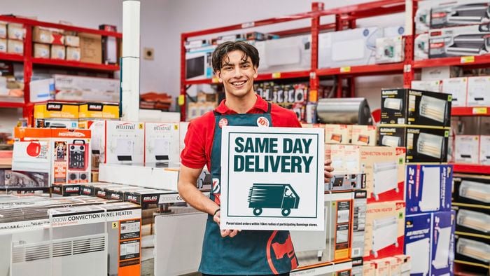 Bunnings team member holding same day delivery sign