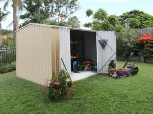 Cream shed and a lawn mower in a garden