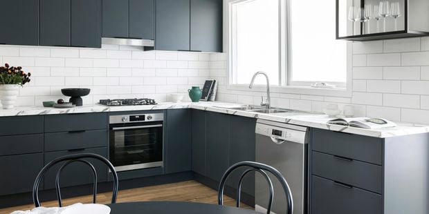 Bright kitchen with dark cabinets and white tiled splashback.