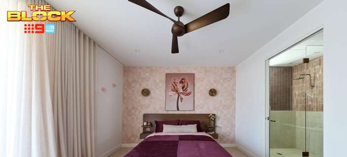 Contemporary bedroom featuring a timber bed with deep purple bedding, patterned feature wall, ceiling fan and adjoining ensuite.