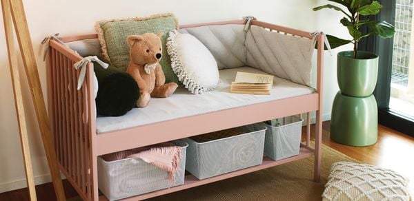 a kids couch with cushion and soft toys on it