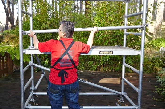 Person assembling mobile scaffolding