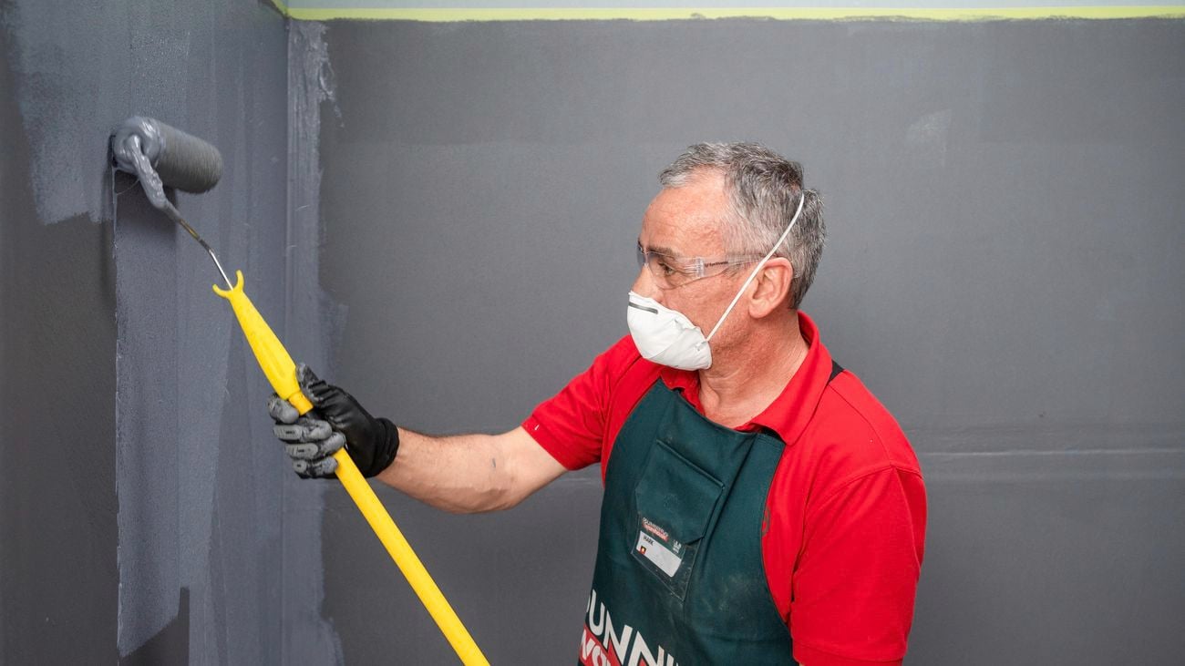 Bunnings team member wearing a mask while applying membrane to a wall