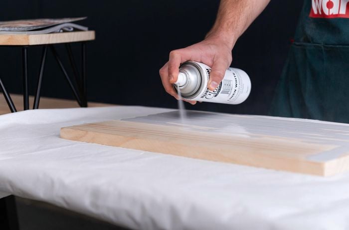 Bunnings team member spray painting timber