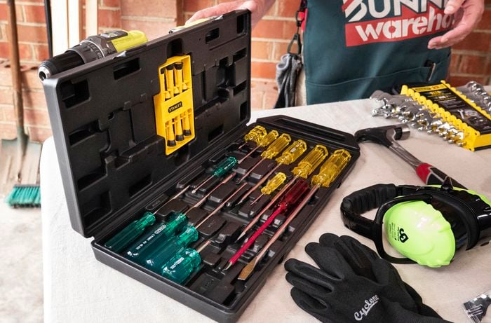 Person opening toolbox and set of spanners next to it.