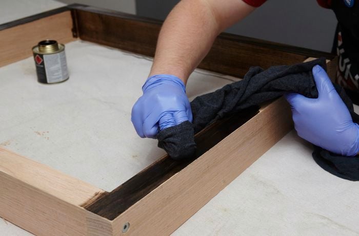 A wooden frame to be used as dining table legs being stained black