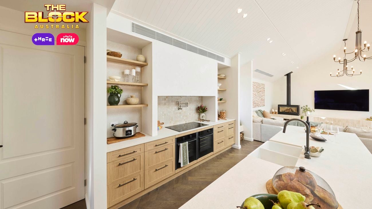 Kitchen with wood cabinetry, open shelves, long island, and living area view.