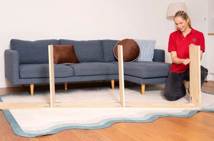 A Bunnings Team Member is testing the stability of a newly assembled shelf frame