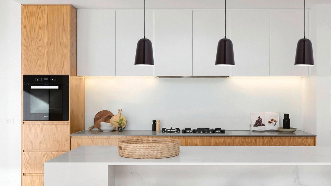 Modern kitchen with hanging black pendant lights.