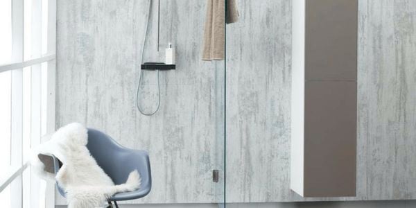 A bathroom with large, stone-look wall panels and a chair