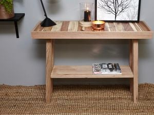 Pallet hall table with lamp, candle and picture frame on it.