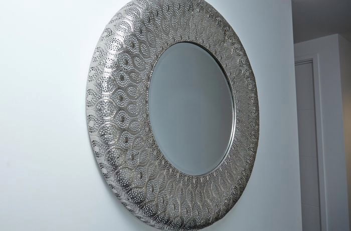 Silver mirror hanging on wall.