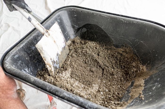 Pour the dry concrete mix in a black wheelbarrow