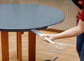 Person painting a round table.