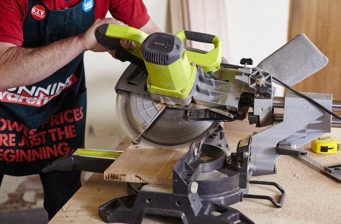 A Bunnings team member using a circular saw to cut timber