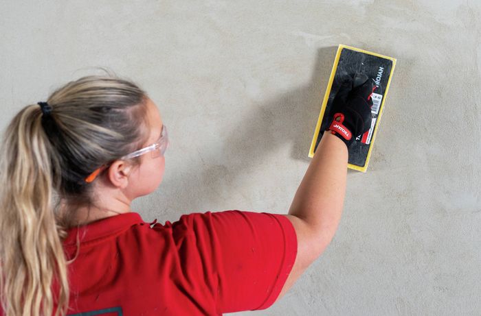 Person using float to finish render coat on wall