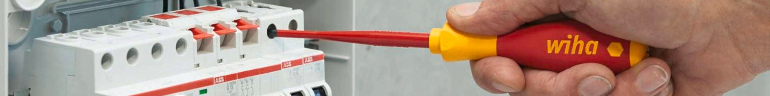 Wiha tools screwdriver being used to screw in a bolt in an electrical board