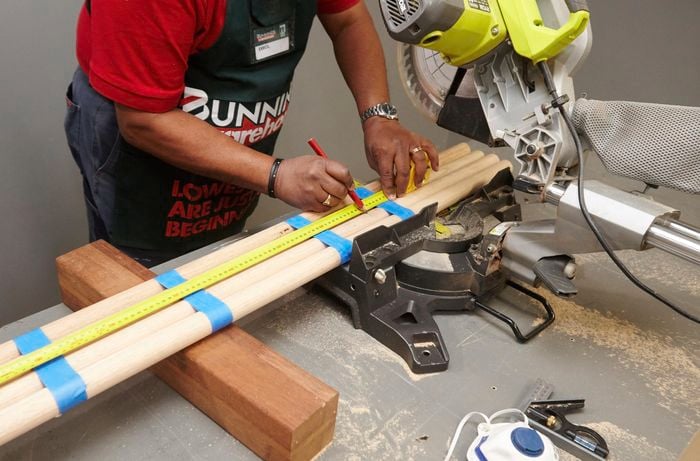 Lengths of dowel being marked for cutting bar stool legs