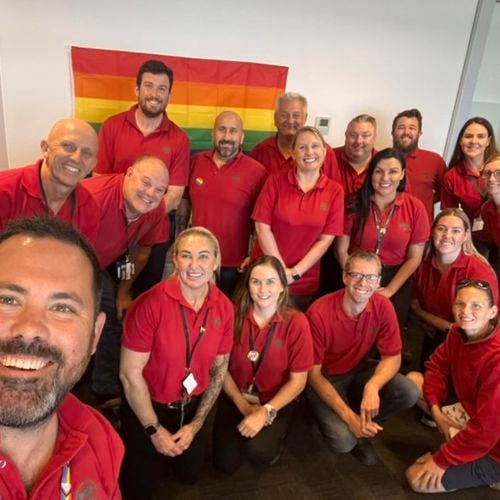 Team in shot with pride flag in background
