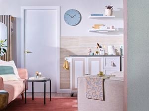 A front-on image of a home showing a kitchen and lounge area decked out in light colour tones.