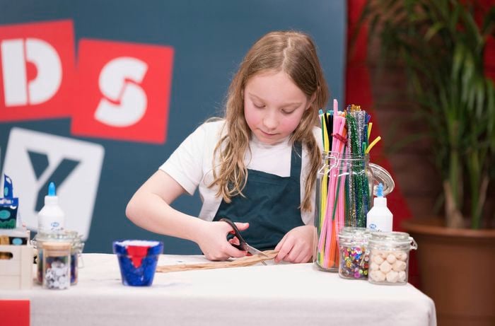 A little girl is cutting stockings at a Bunnings DIY workshop.
