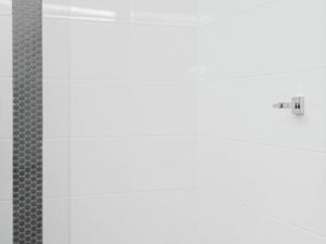 A chrome wall bracket is mounted on a white tiled wall 